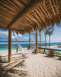 Scenic view of beach and hammock against sky