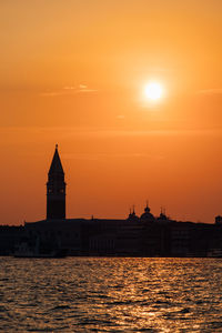 Grand canal by silhouette church of san giorgio maggiore against sky during sunset