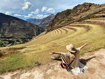 Woman sitting against mountains