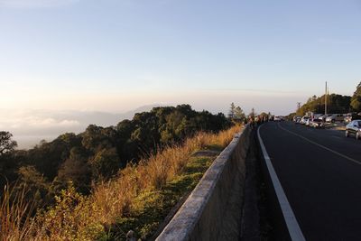 Road leading towards city against sky during sun rise