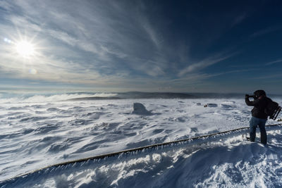 Man standing on snow against sky during winter