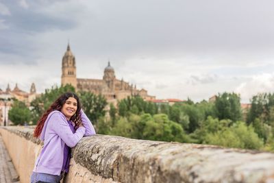 Portrait of young woman standing against mountain