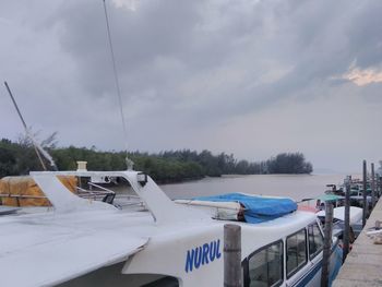 Boats moored in sea against sky