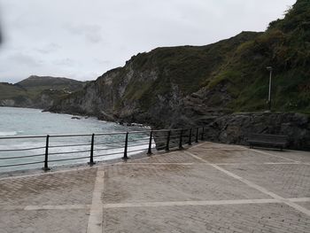 Footpath by sea against sky