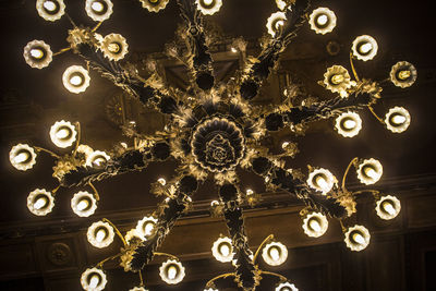 Low angle view of illuminated light bulbs hanging from ceiling