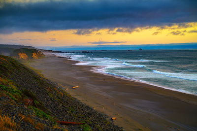 Scenic view of beach against sky during sunset