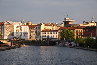 River amidst buildings in city against sky