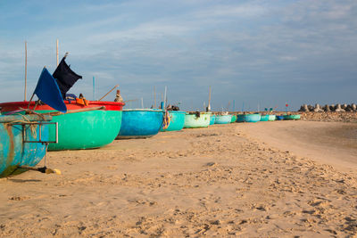 Boats moored on beach against sky