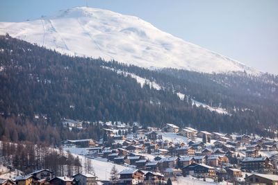 High angle view of townscape and snowcapped mountains against sky