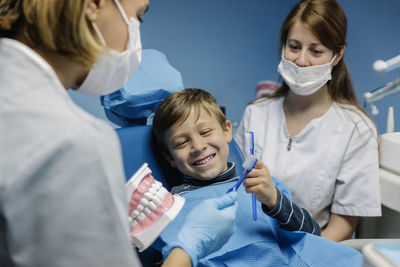 Dentists examining boy in clinic