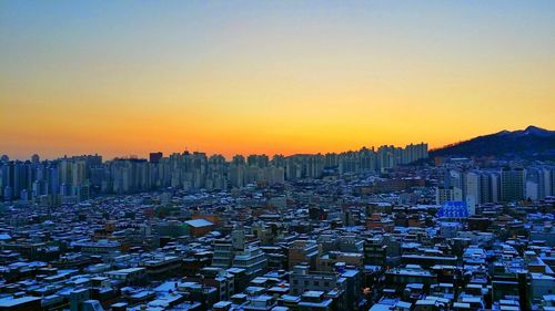 City buildings against clear sky during sunset