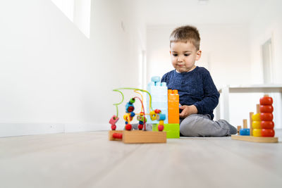 Cute boy playing with toys at home