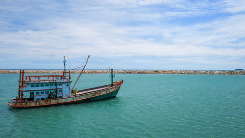 Fishing boat in sea against sky