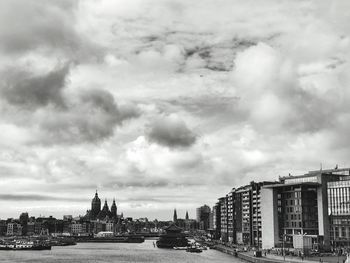 Buildings in city against cloudy sky