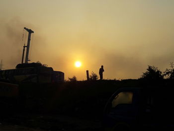 Silhouette of car against sky during sunset