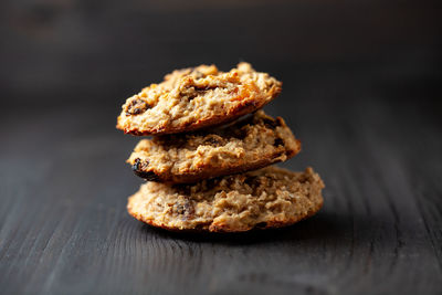 Homemade oatmeal cookies with raisins on a black wooden background