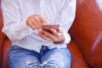 Midsection of man using mobile phone