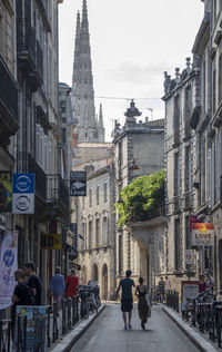 People walking on street amidst buildings in city