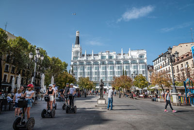 People on street in city against sky