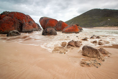 Rocks on beach against sky