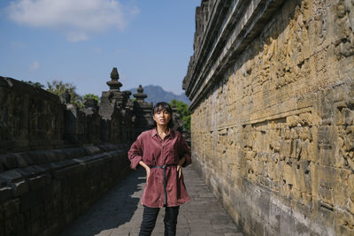 Portrait of woman standing in temple against sky