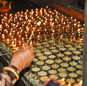 Close-up of hand holding illuminated candles