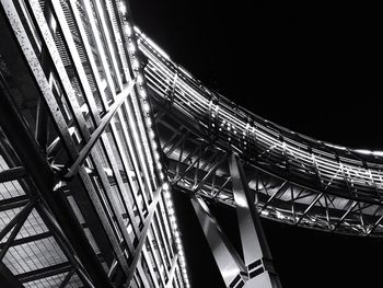 Low angle view of illuminated bridge against sky at night