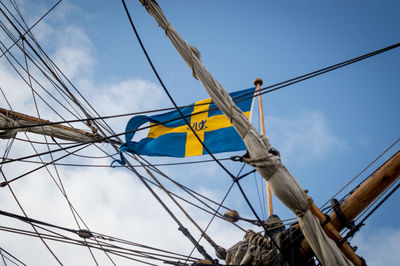 Low angle view of flag and mast against sky