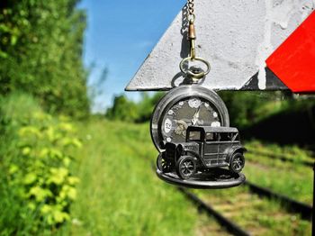 Close-up of camera hanging on metal against sky