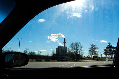 Cars on road against cloudy sky