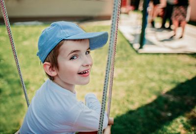 Portrait of cute boy sitting on swing