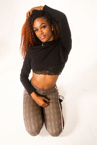 Portrait of beautiful young woman standing against white background