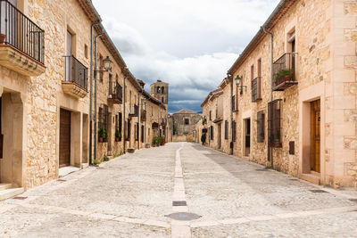 Narrow alley amidst buildings against sky in city