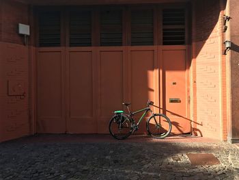 Bicycle parked against building