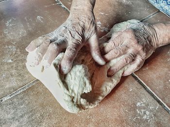 Cropped hands kneading dough