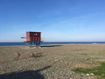 Lifeguard hut on beach against sky