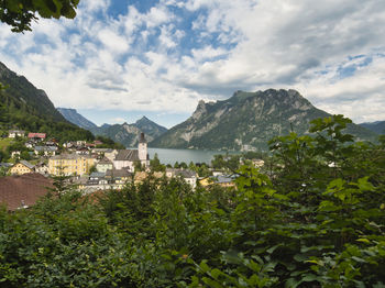 Scenic view of townscape by mountains against sky