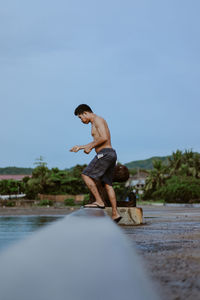 Man fishing at the beach against clear sky