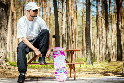 Full length of boy sitting on plant against trees