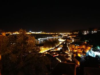 Illuminated cityscape against sky at night