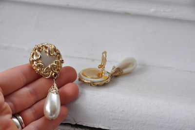 Cropped hand holding earring at table