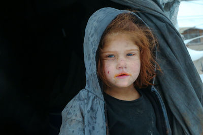 A syrian refugee child at the door of his snow covered tent