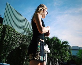 Low angle view of woman standing against sky