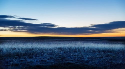 Scenic view of field against dramatic sky