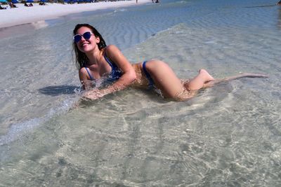 Sensuous young woman wearing bikini relaxing at beach