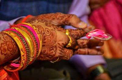 Cropped hands of couple performing traditional ritual during wedding ceremony