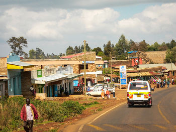 People on road against sky in city