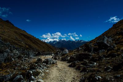 Scenic view of snow covered mountains against blue sky