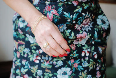 Close-up midsection of woman wearing floral patterned dress