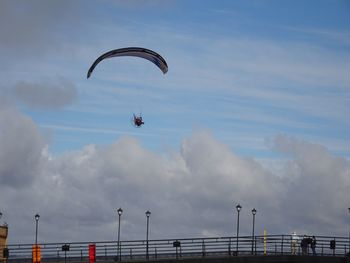 Low angle view of person paragliding against sky